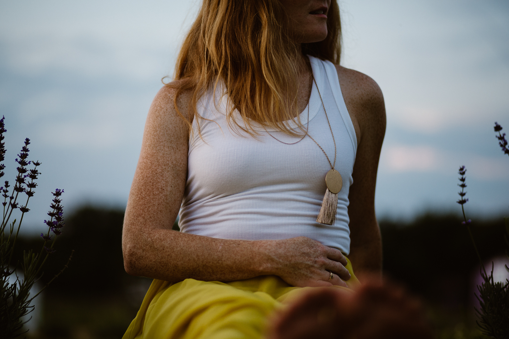 Red headed woman in yellow skirt at sunset in a lavender field.